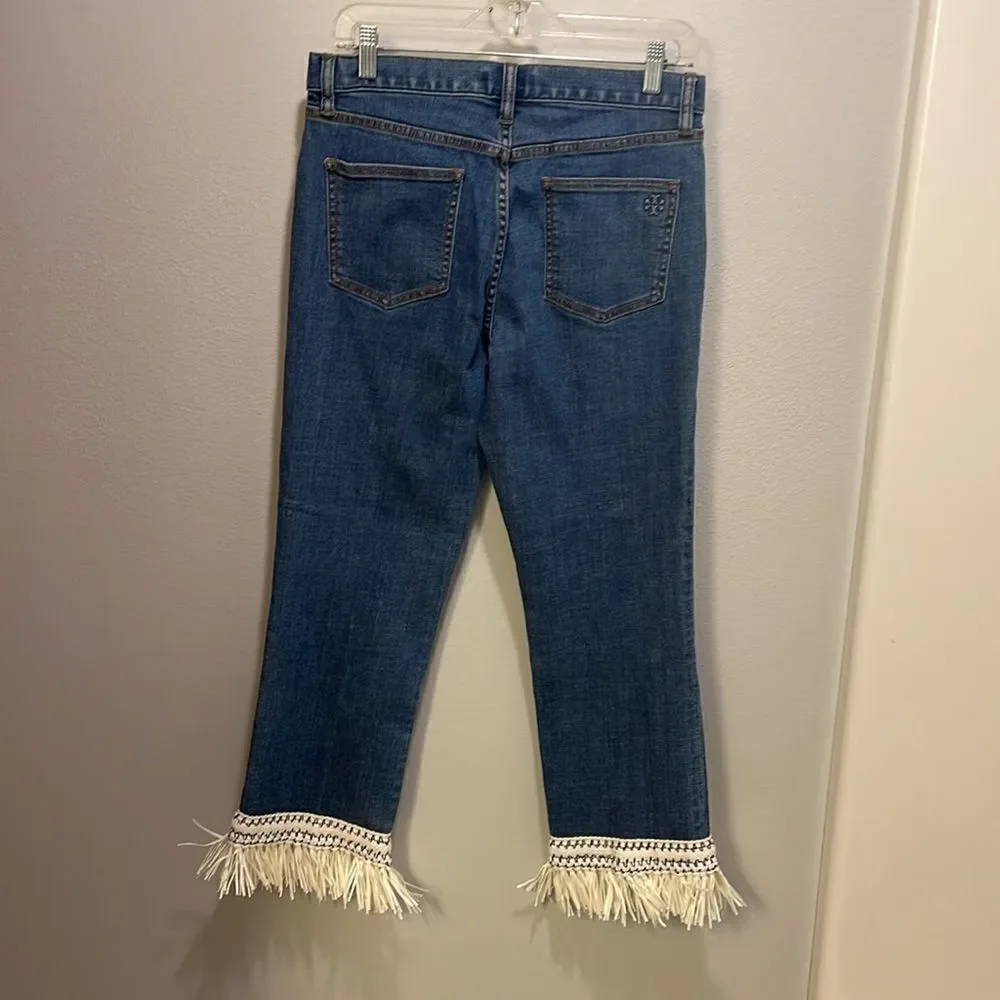 Tory Burch Connor jeans in medium allover stone wash. Cropped. Raffia fringed